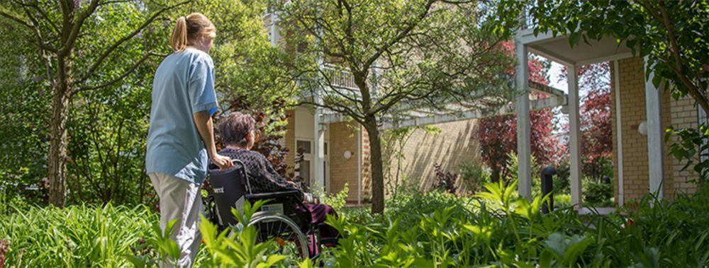 Wer zwischen 16 und 27 Jahren alt ist, kann im St. Marien-Krankenhaus Berlin ein FSJ (Freiwilliges Soziales Jahr) zu absolvieren Eine Schülerin, die ihr Freiwilliges Soziales Jahr im Sankt Marien-Krankenhaus Berlin absolviert, schiebt eine Patientin im Rollstuhl durch den Park am Krankenhaus