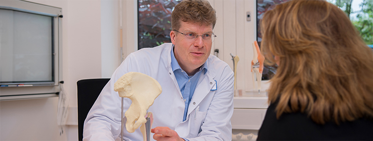 Dr. Götz, Chefarzt Orthopädie und Unfallchirurgie, Leiter EndoProthetikZentrum, St. Marien-Krankenhaus Berlin, im Patientengespräch Doktor Götz, Chefarzt der Orthopädie und Unfallchirurgie und Leiter des EndoProthetikZentrums im Sankt Marien-Krankenhaus Berlin h erklärt einer Patientin den Hüftgelenkersatz