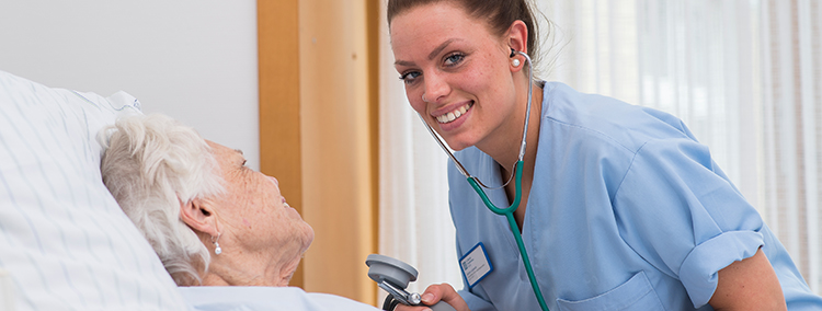 Eine Gesundheits- und Krankenpflegerin versorgt im Sankt Marien-Krankenhaus Berlin eine Patientin